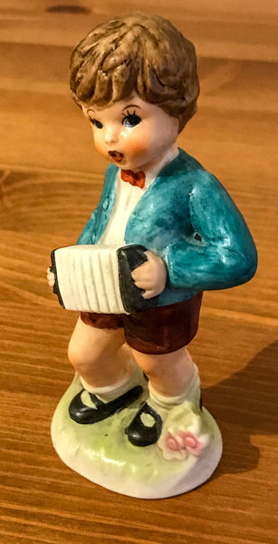Figurine of young boy playing concertina - TheReedLounge.com