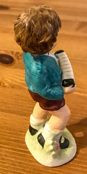 Figurine of young boy playing concertina - TheReedLounge.com